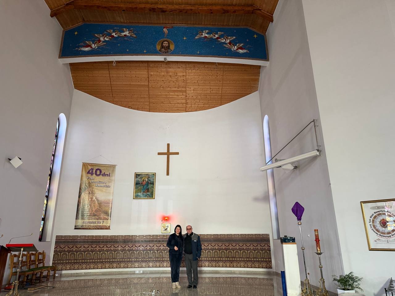 Interiér kaple s mozaikovým ornamentálním pásem nad oltářem